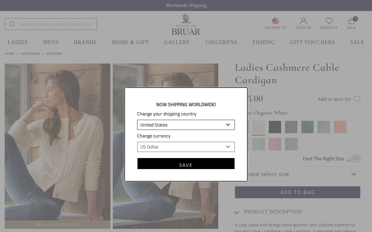 The Ladies Cashmere Cable Cardigan page, captured October 13, 2026, listed at $275.00 with ten colorways; the shipping-country modal partly covers the price. Source: houseofbruar.com/cash-cable-cardigan-white.